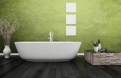 Moderner Raum mit freistehender Badewanne vor grüner Wand.